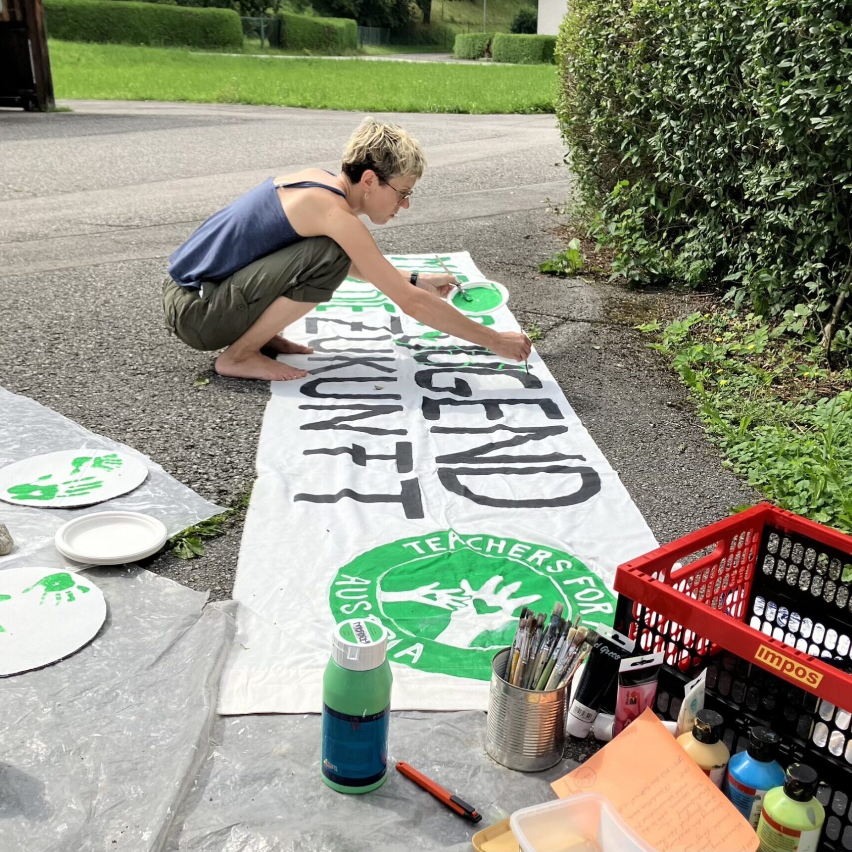 Teacher beim Malen eines "Mit der Jugend für die Zukunft"-Banners