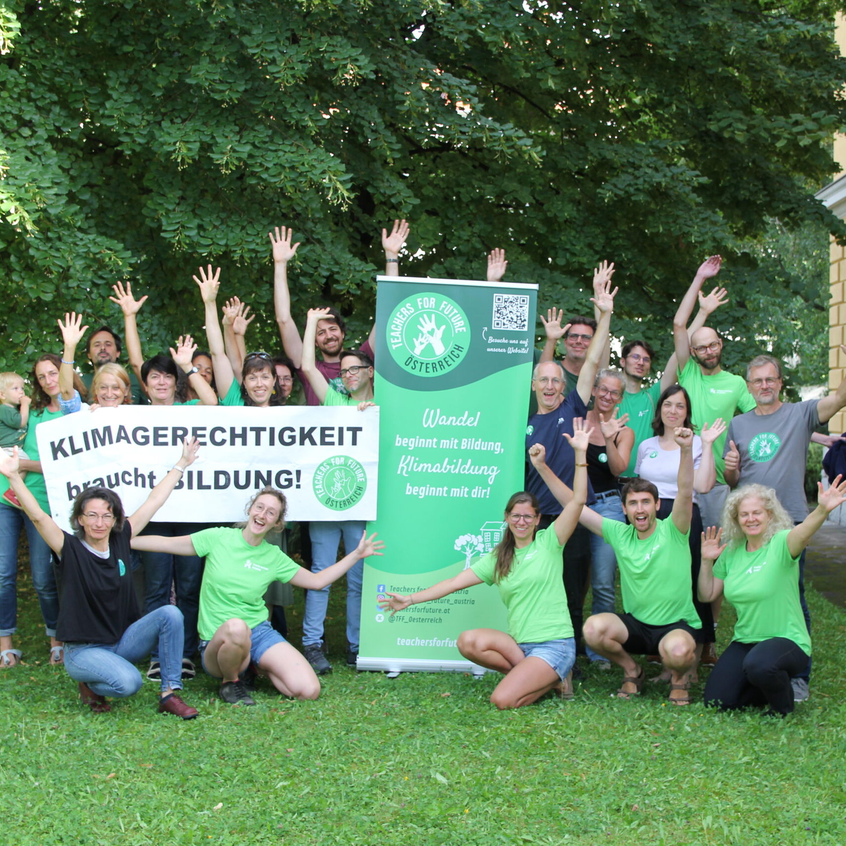 Teachers For Future Österreich jubeln über die Gründung einer neuen Regionalgruppe. Auf einem Rollup-Banner in der Mitte steht unter dem TFF-Logo: "Wandel beginnt mit Bildung, Klimabildung beginnt mit dir!"