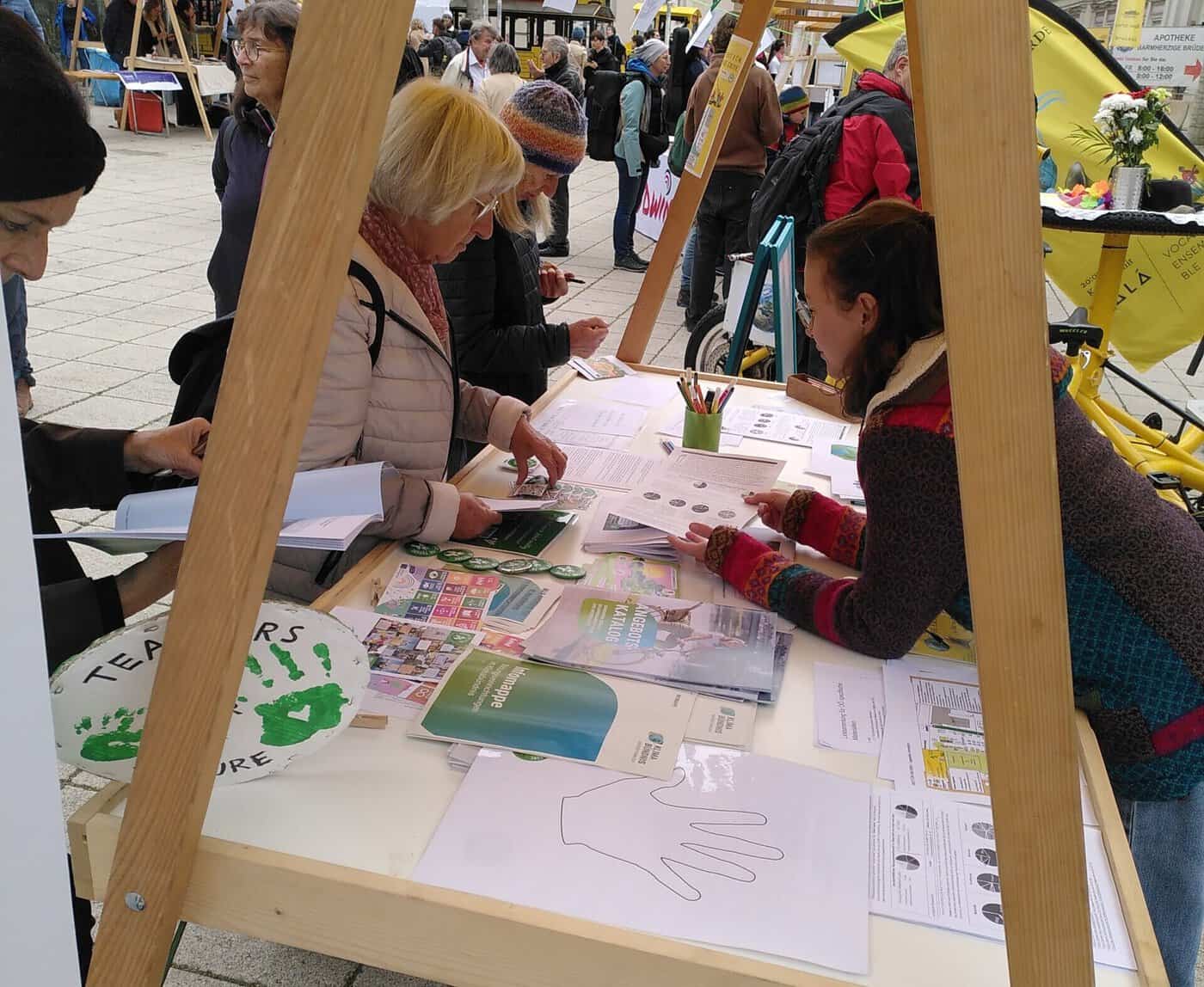 Teachers For Future tauschen sich an ihrem Infostand mit interessierten Lehrkräften aus.