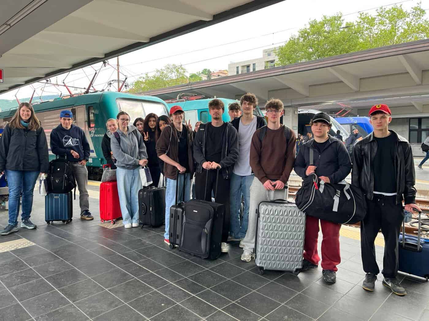 Schüler:innen des BORG Neulengbach posieren auf dem Bahnsteig in einem italienischen Bahnhof.