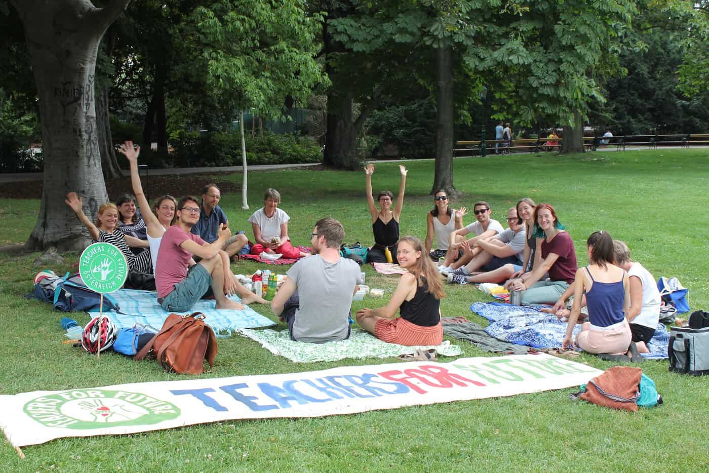 Eine große Teachers for Future gut gelaunt bei einem Arbeitstreffen im Park.