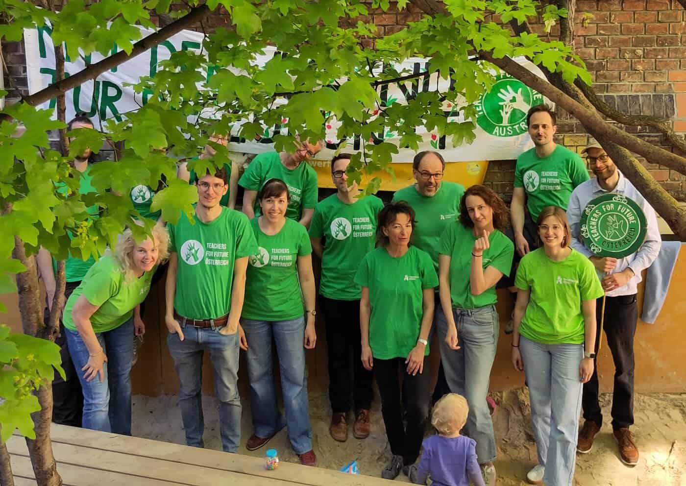 Gruppenfoto von Teachers for Future, die unter dem Blätterwerk eines Baumes hervorschauen.
